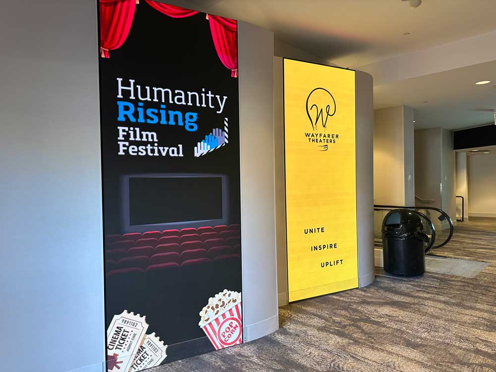 Humanity Rising Film Festival and Wayfarer Theater Humanity Rising Film Festival sign next to Wayfarer Theater sign in the lobby of the theater